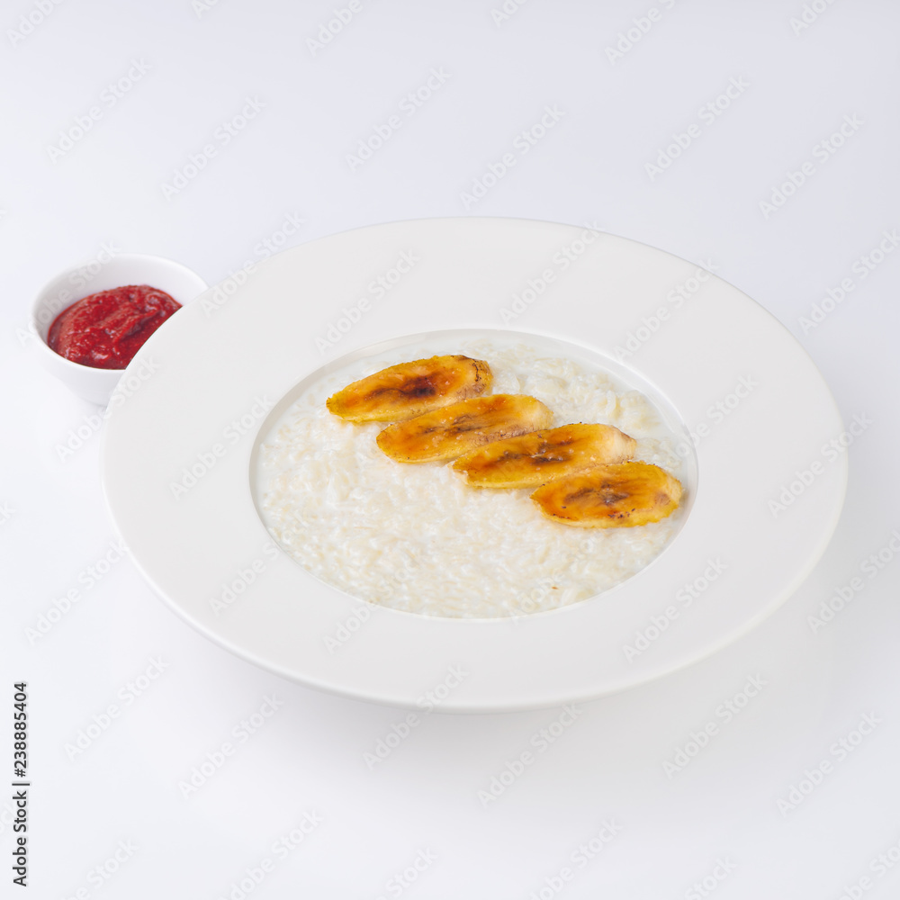 A plate of oatmeal porridge with fried banana. Hot and healthy breakfast every day, diet food.