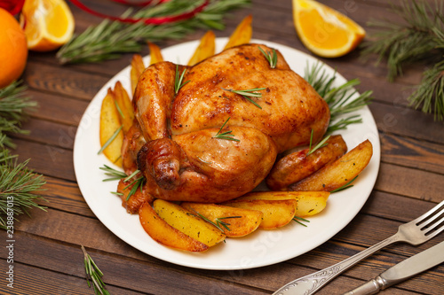 Roasted whole chicken with Christmas decoration. Wooden background.