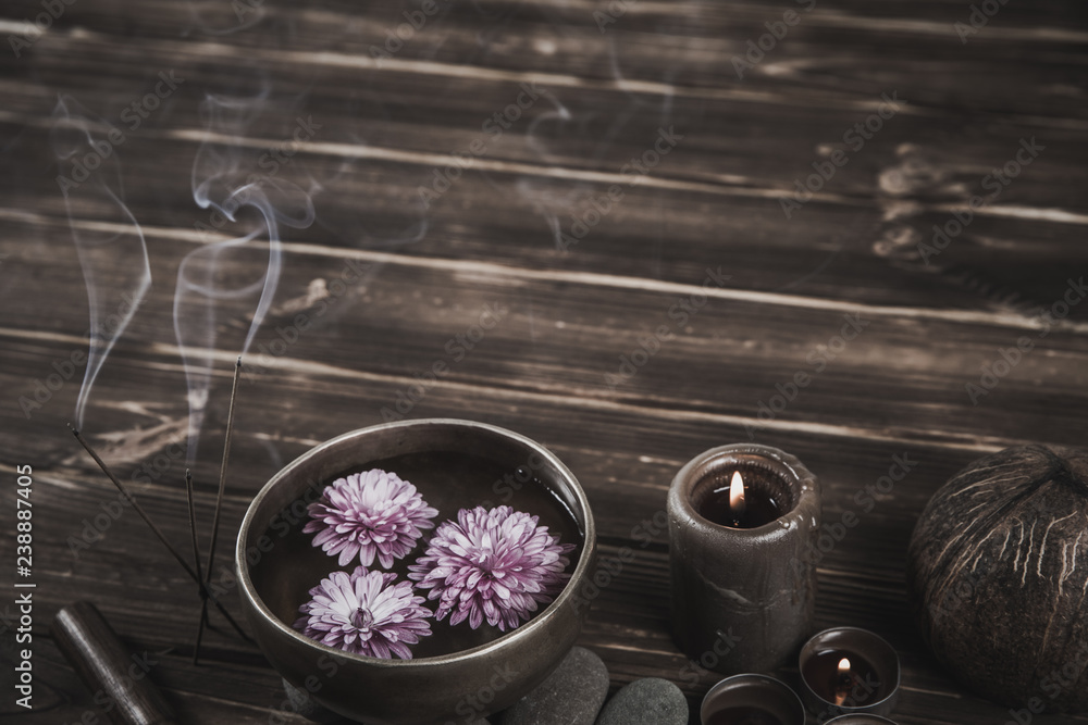 Singing bowl with candles with pebbles on dark wooden background Singing bowl with candles with pebbles on dark wooden background