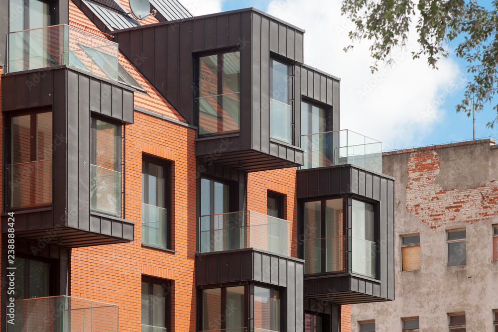 Fototapeta premium Contemporary Residential Building Exterior in the Daylight with modern balcony and brick facade