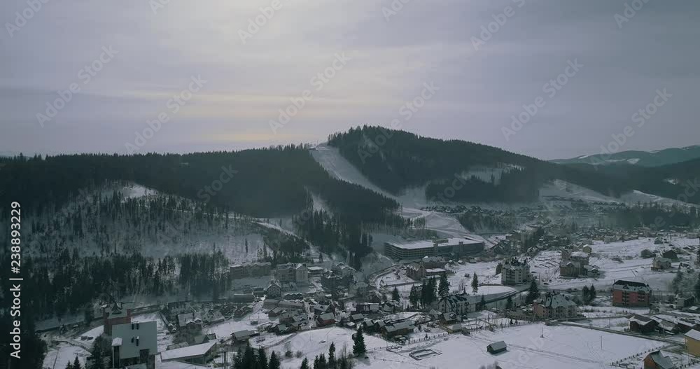 Drones flying snow-covered village in the mountains. Building. Aerial view. Winter. Drones flying snow-covered village in the mountains. Building. Aerial view. Winter.