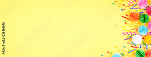 Birthday party background on yellow. Top view. Border made of colorful serpen...