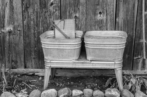 Time For New Appliances.  Old fashioned antique metal washtub and washboard in black and white in horizontal orientation.  photo