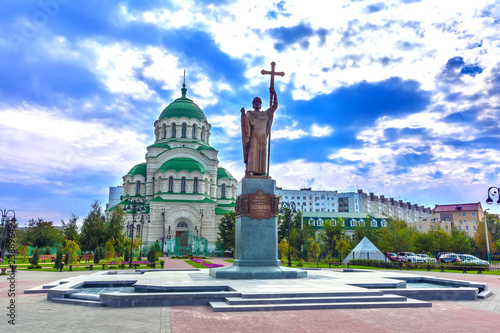 Tableau sur toile Beautiful colorful square in front of the Christian church in the city center on a cloudy day with thick blue clouds