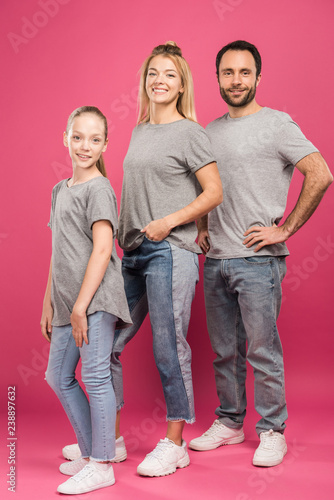 beautiful parents and blonde daughter posing together, isolated on pink