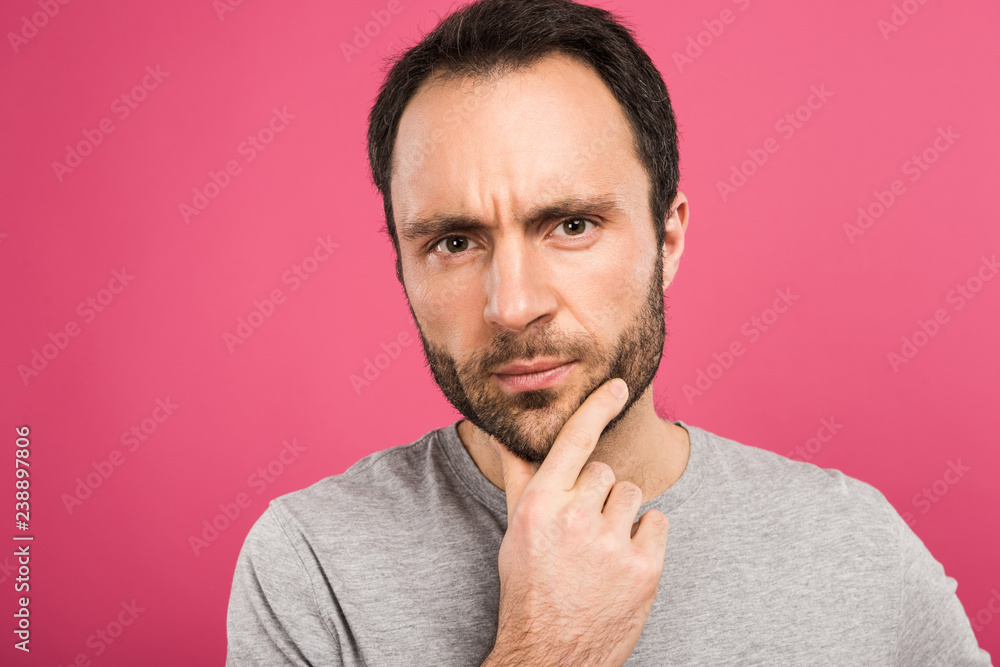 portrait of pensive man looking at camera, isolated on pink portrait of pensive man looking at camera, isolated on pink