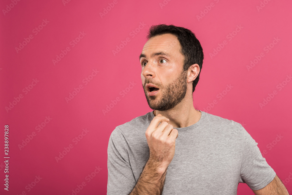 portrait of shocked man looking aside, isolated on pink portrait of shocked man looking aside, isolated on pink