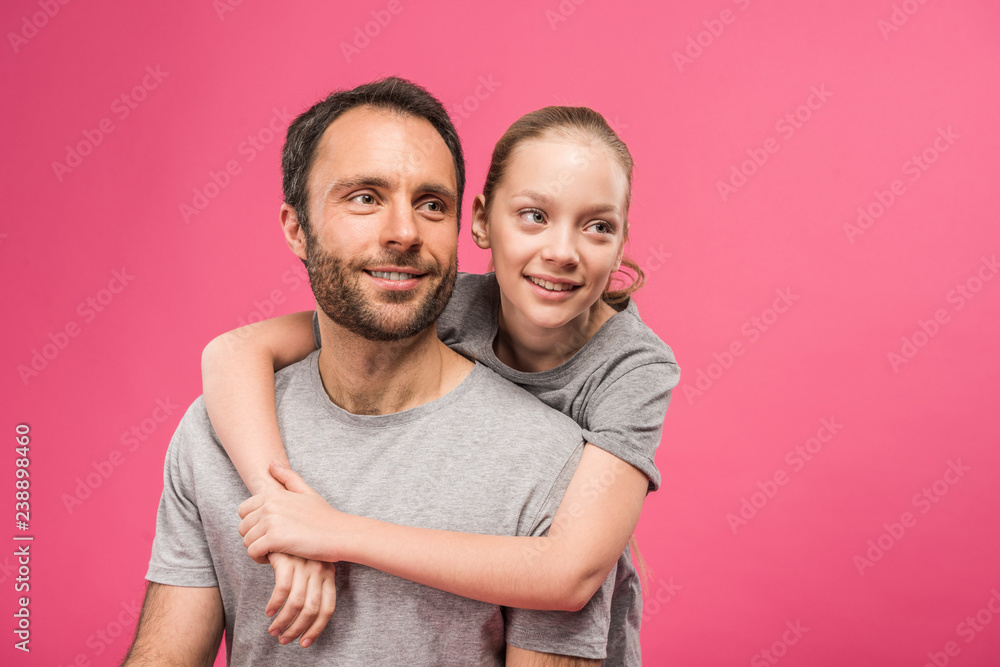 smiling blonde daughter hugging her dad, isolated on pink smiling blonde daughter hugging her dad, isolated on pink