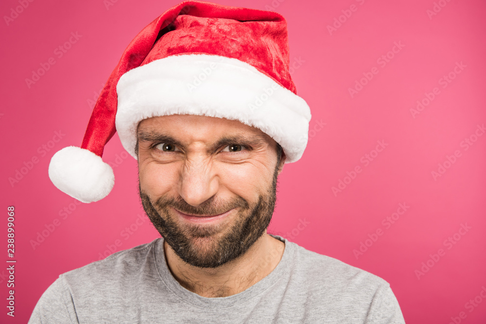 portrait of funny smiling man in santa hat, isolated on pink portrait of funny smiling man in santa hat, isolated on pink