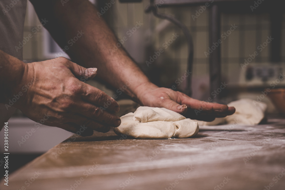 Bäcker Hände kneten Teig auf Tisch