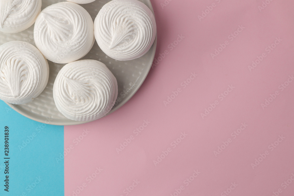 Sweet white marshmallow on a plate on a bright trendy blue and pink background. Sweets. dessert. top view with space for text Sweet white marshmallow on a plate on a bright trendy blue and pink background. Sweets. dessert. top view with space for text