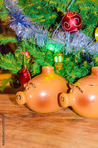 New Year's card yearof the pig piglet doll pots on the background of a dressed Christmas tree photo