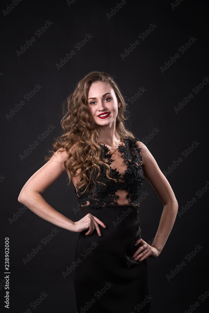 Portrait of a smiling young girl in a lace dress on a black background Portrait of a smiling young girl in a lace dress on a black background