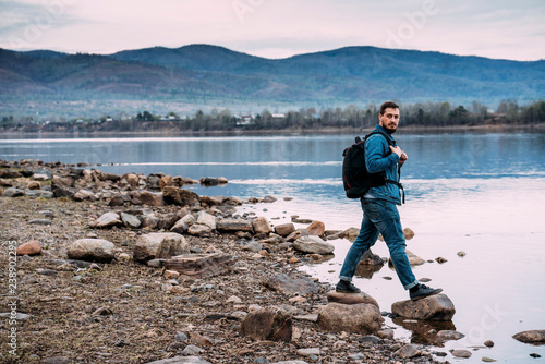 Russia, Amur Oblast, man with backpack at Zeya River photo