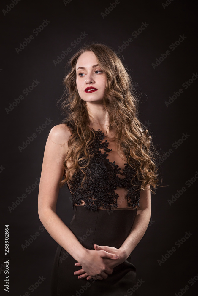 Portrait of a young girl in lace dress on a black background