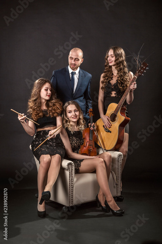 Man surrounded by beautiful girls musicians in evening lace dresses