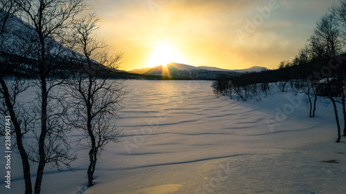 Sunset over a frozen snowy ...