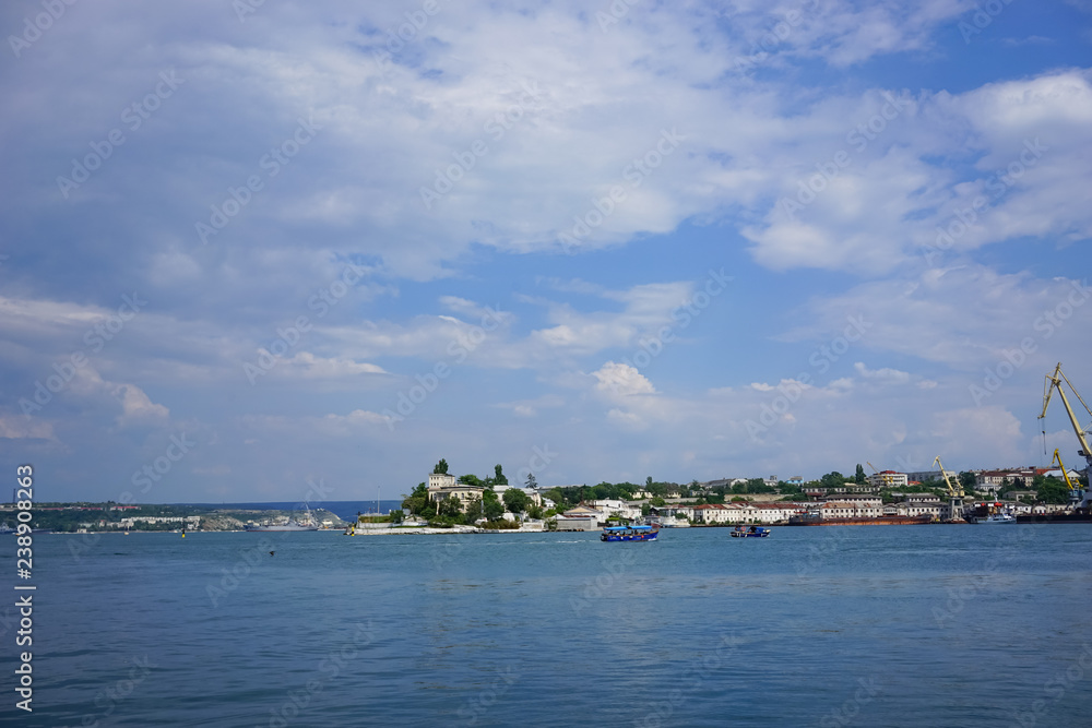 Urban landscape with coastline, sea and sky with clouds. Urban landscape with coastline, sea and sky with clouds.