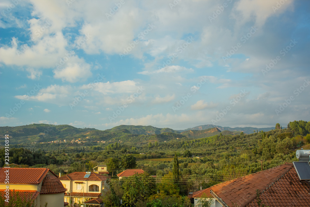 village place and houses with orange shingles roofs in rain forest mountain landscape tropic exotic environment in summer clear weather time village place and houses with orange shingles roofs in rain forest mountain landscape tropic exotic environment in summer clear weather time
