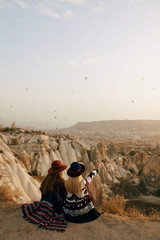 Travel. Women Looking At Flying Hot Air Balloons In Sky