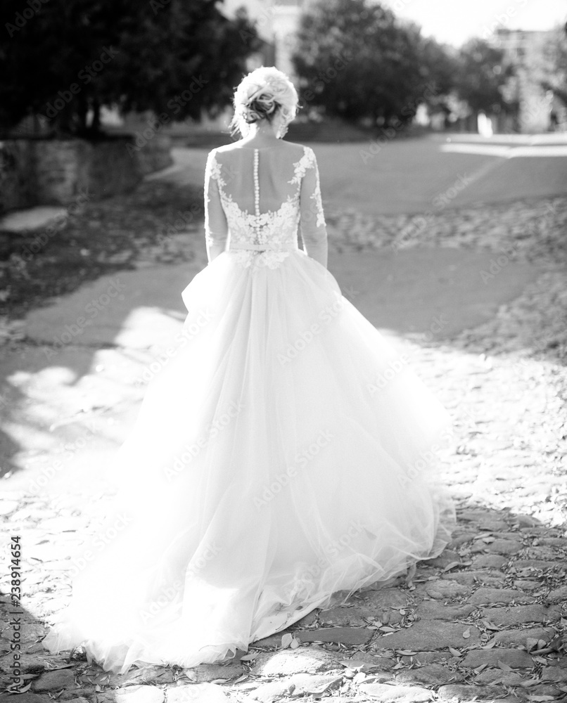 Beautiful blonde bride in white dress in the garden Beautiful blonde bride in white dress in the garden