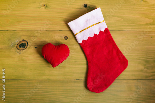Image of Christmas Stocking and heart on wooden table.