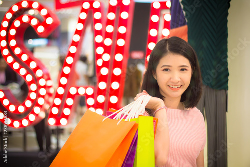 Young Woman holding fashion shopping bag in mall.