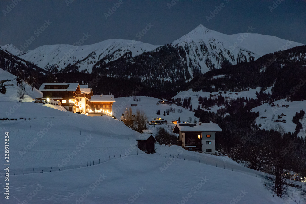 little village in the alps covered with snow at night