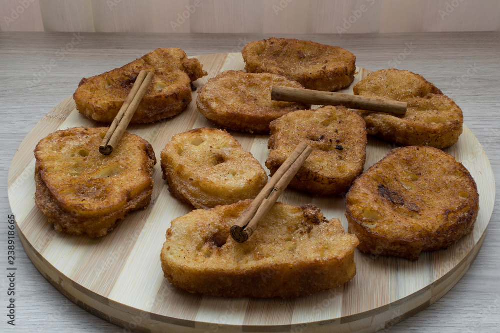 Homemade Spanish milk torrijas with cinnamon sticks. Traditional Easter dessert Homemade Spanish milk torrijas with cinnamon sticks. Traditional Easter dessert