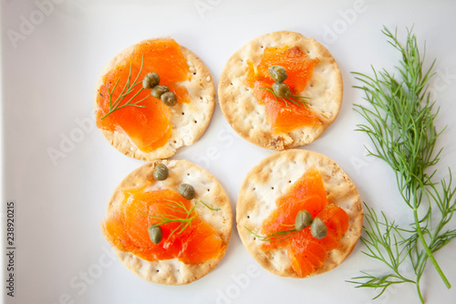 cured salmon appetizer plate, with capers, dill and crackers, plated for a party