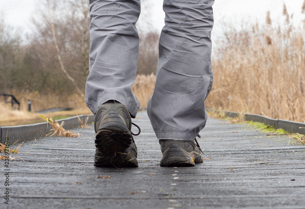 Man walking along a boardwalk enjoying nature Man walking along a boardwalk enjoying nature