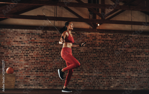 Quadro em tela Healthy woman skipping rope at gym