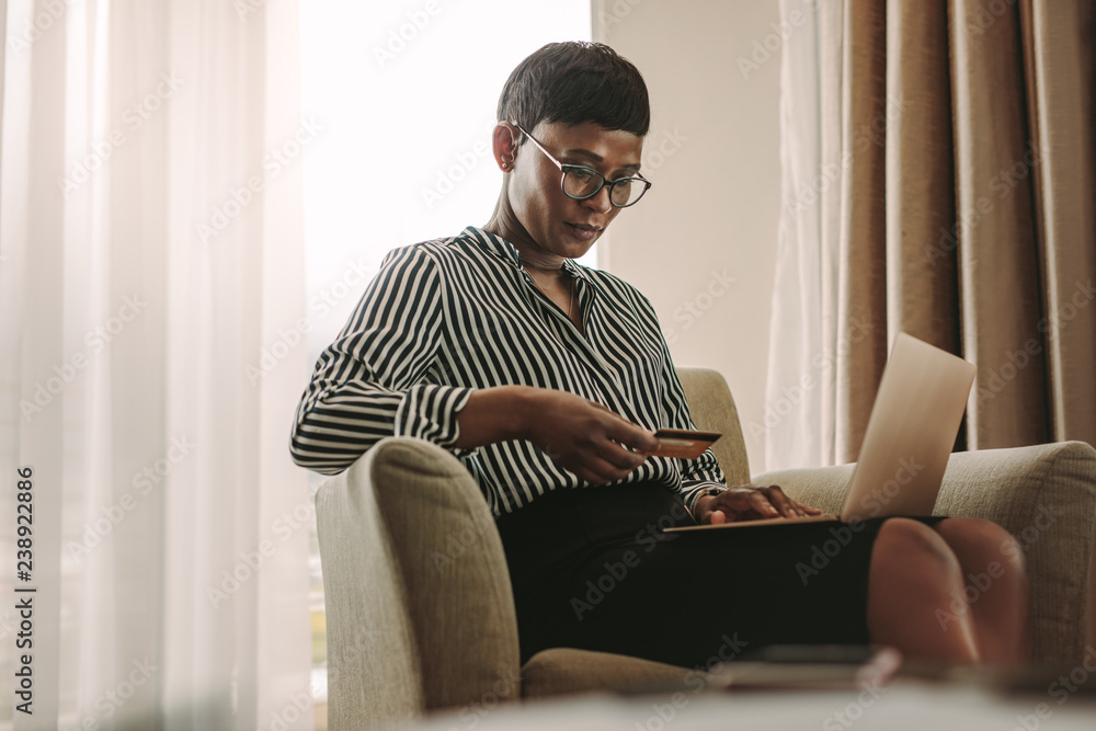 Woman on business trip doing payment using credit card and lapto Woman on business trip doing payment using credit card and lapto