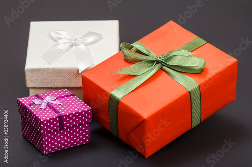 Gift boxes tied with ribbons on black background.