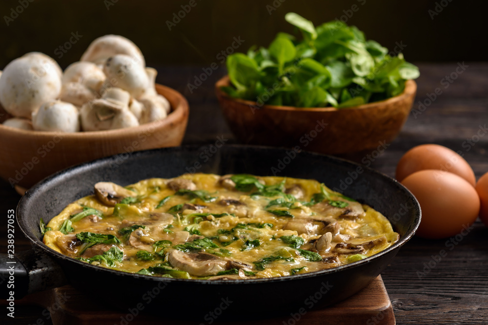 Omelette with mushrooms and cheese, on dark wooden background. Omelette with mushrooms and cheese, on dark wooden background.