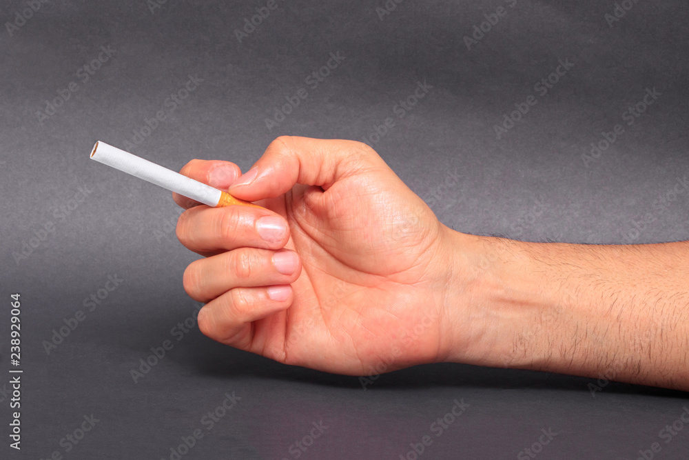 Man holding cigarette between fingers Man holding cigarette between fingers