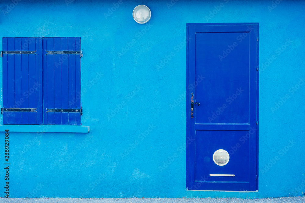 Facade of blue building with blue doors and shutters