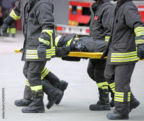 Firefighters carry a wounded man on a stretcher