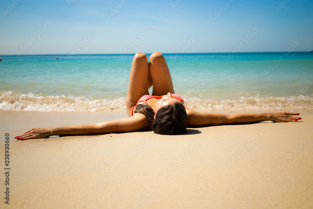 girl lying on the white beach on the blue sea