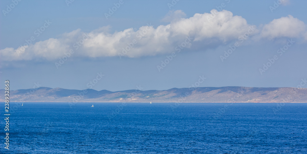 soft focus panoramic south landscape with vivid blue sea water surface on foreground and long mountain ridge on horizon on background wallpaper pattern concept 