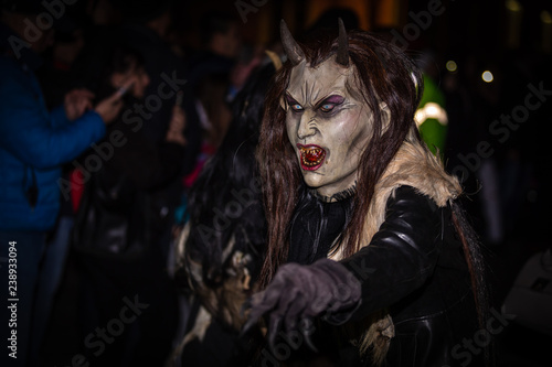 Closeup on female horned devil in traditional krampuslauf with wooden masks in Retz, Austria. The Krampus is in the tradition of a fright figure in the company of St. Nicholas