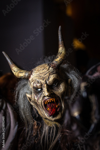 Closeup portrait of horned devil in traditional krampuslauf with wooden  masks in Retz, Austria. The Krampus is in the tradition of a fright figure  in the company of St. Nicholas Stock Photo