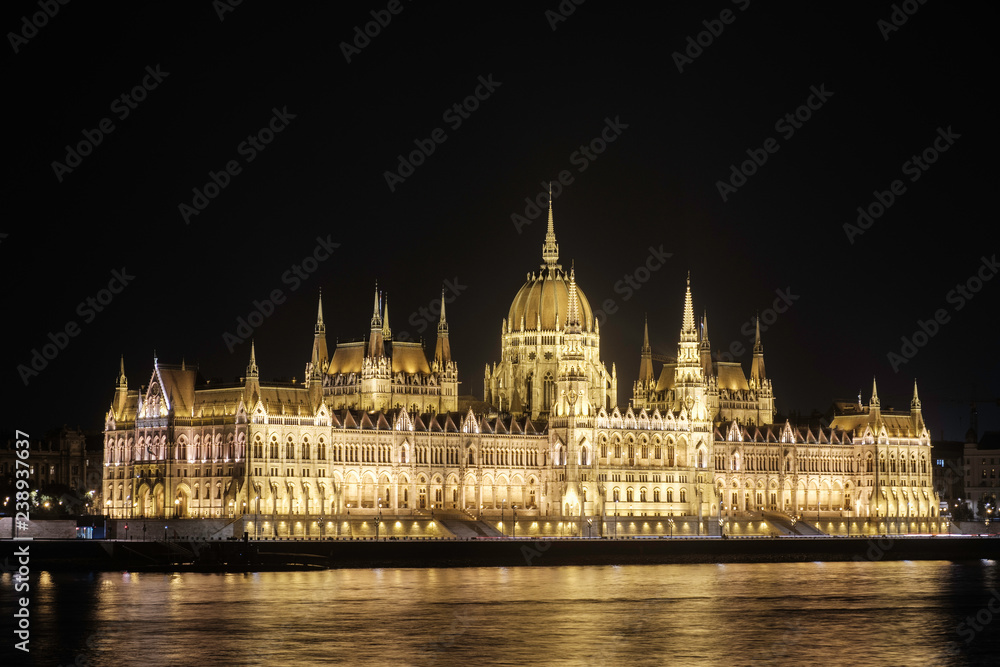 Fototapeta premium Malowniczy widok na węgierski parlament w starożytnym historycznym mieście turystycznym Budapeszcie i słynnej Dunaju w oświetleniu nocnym na Węgrzech