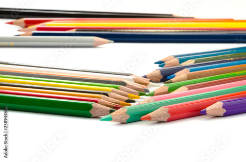 Color pencils pink light blue green yellow and red on white background.