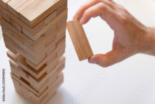 Tower of wooden cubes on a light background. Concept - successful construction. Copy space. Financial Pyramide. Crisis conditions. Board game - Genga.