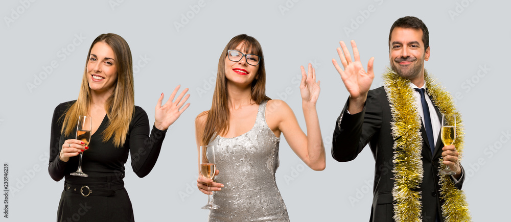 Group of people with champagne celebrating new year 2019 saluting with hand with happy expression