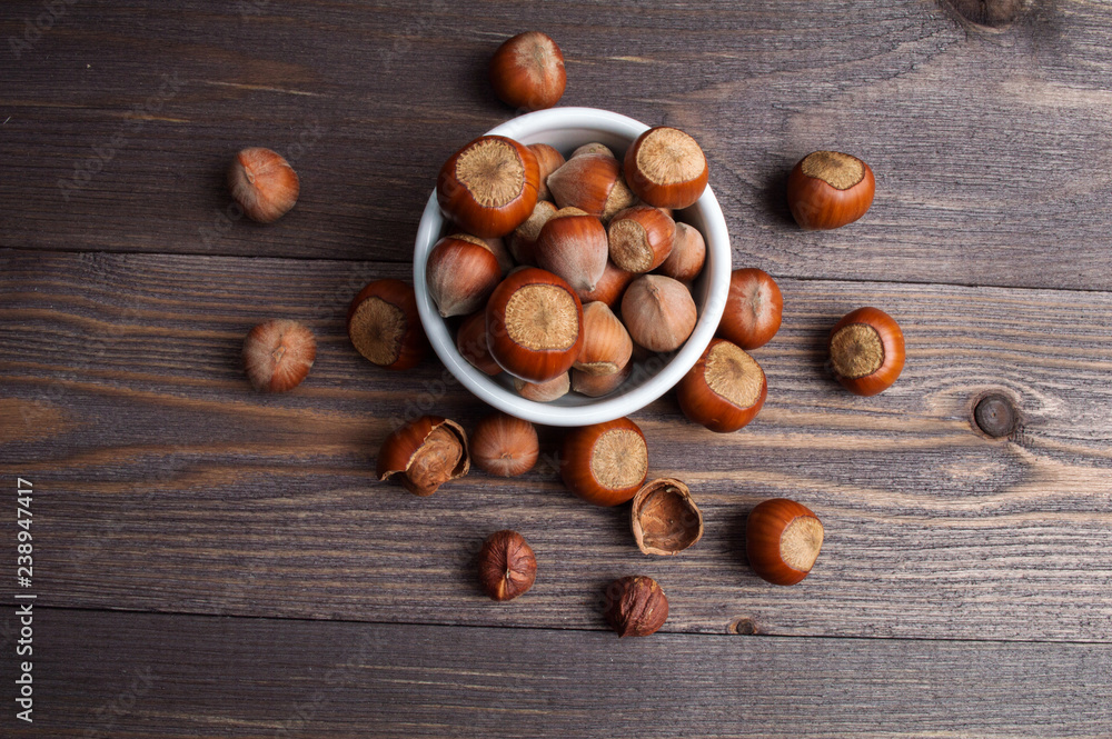 Filbert nuts in white porcelain bowl on wooden background Filbert nuts in white porcelain bowl on wooden background