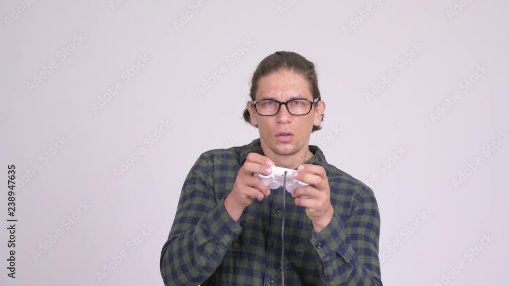 Handsome hipster man looking focused while playing games Handsome hipster man looking focused while playing games