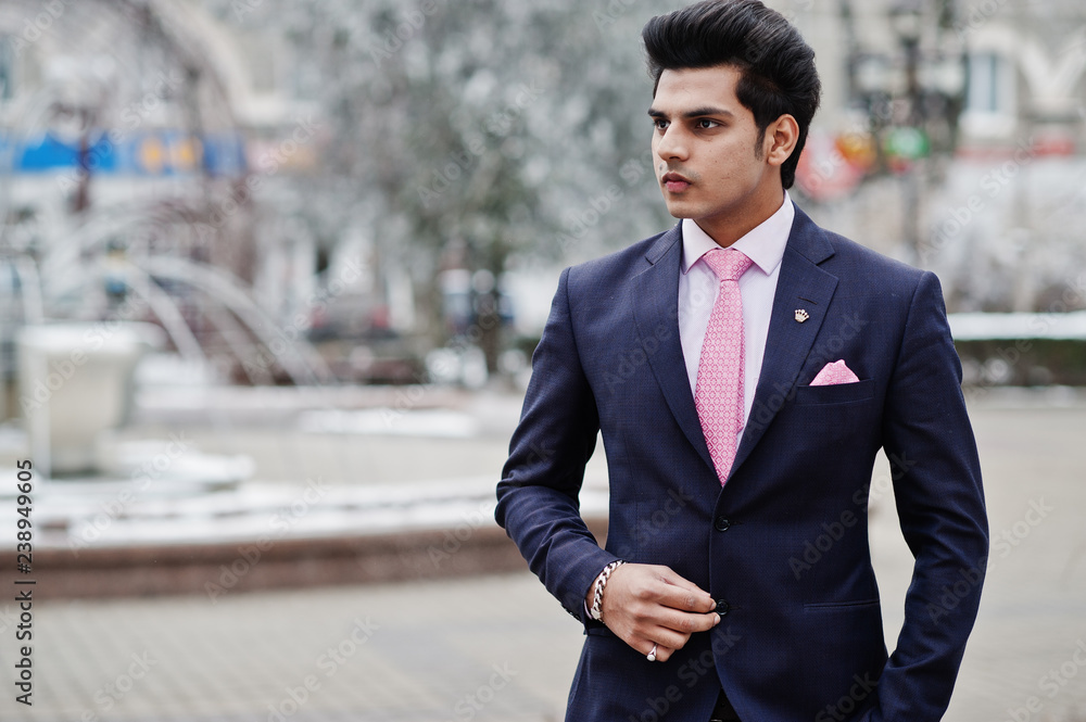 Elegant indian macho man model on suit and pink tie posed on winter day.