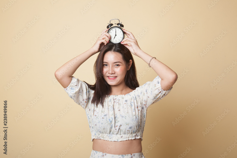 Young Asian woman smile with a clock. Young Asian woman smile with a clock.